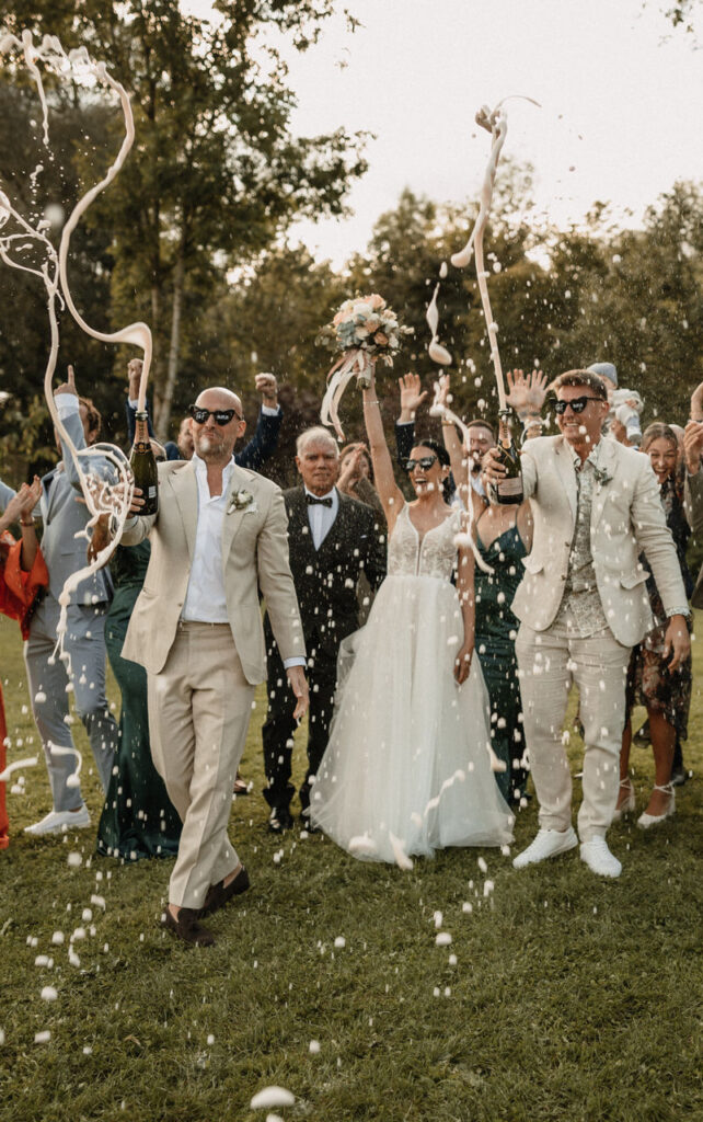 Brautpaar macht Champagner Party mit den Gästen und alle jubeln