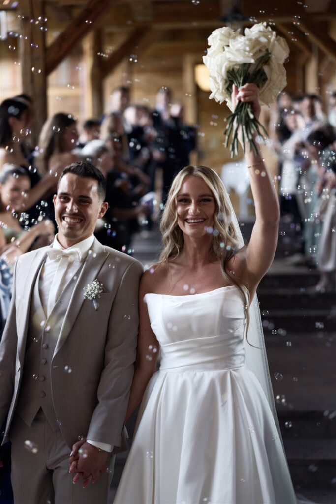 Brautpaar und Gäste jubeln beim Auszug