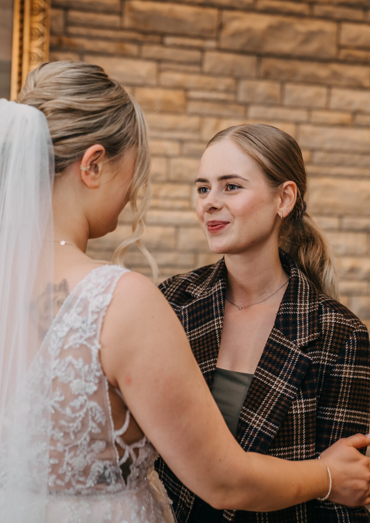 Hochzeitssängerin umarmt Braut bei Hochzeit