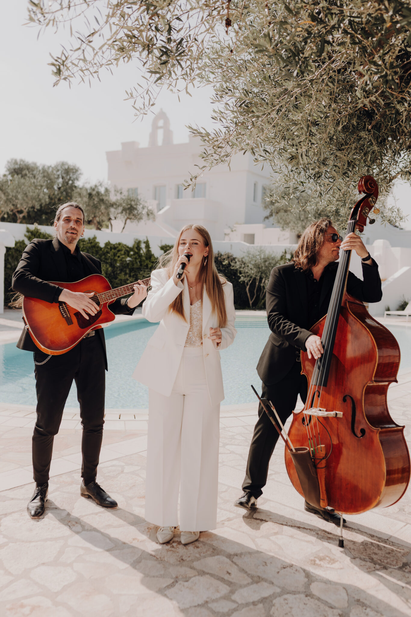 Hochzeitsband steht mit Instrumenten vor Pool vor Masseria.