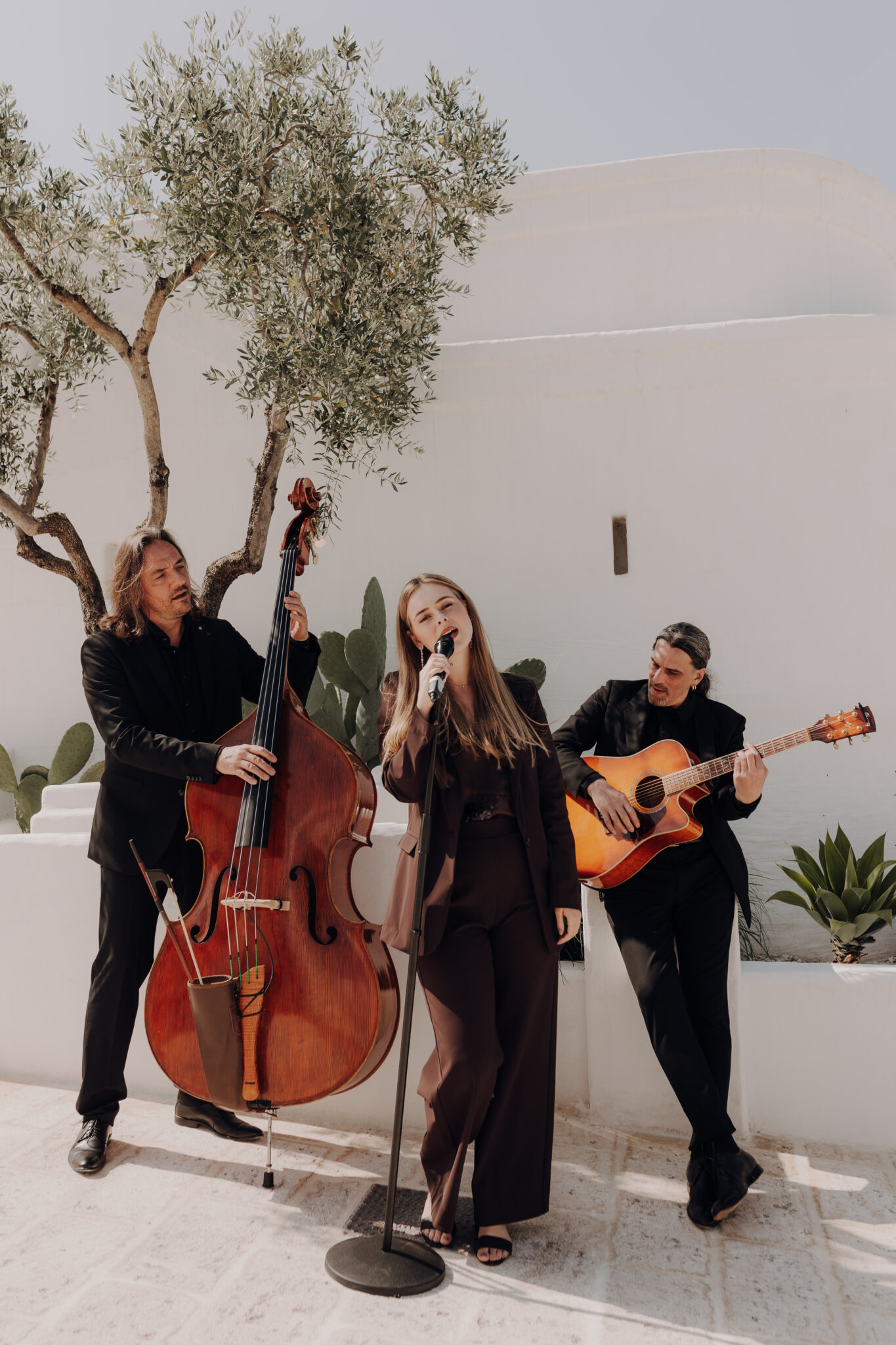 Live-Band mit Sängerin, Kontrabass und Gitarrist spielt in eleganter Location.